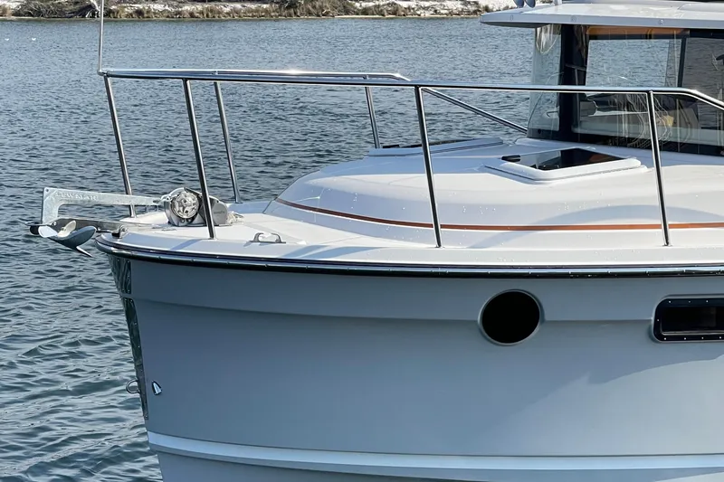 Slide: The Image of 2023 Ranger Tugs R-25 boat bow on water, featuring sleek design and chrome railings. - 6