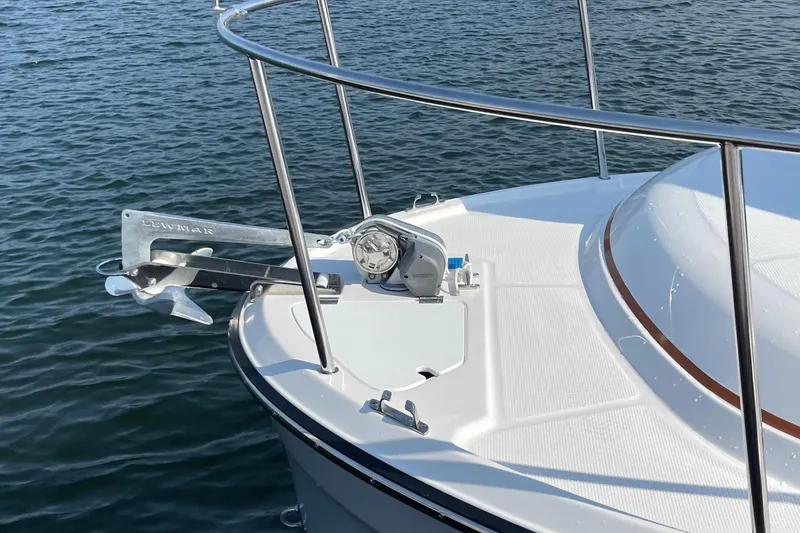 Slide: The Image of 2023 Ranger Tugs R-25 boat bow with anchor and railing on water. - 9