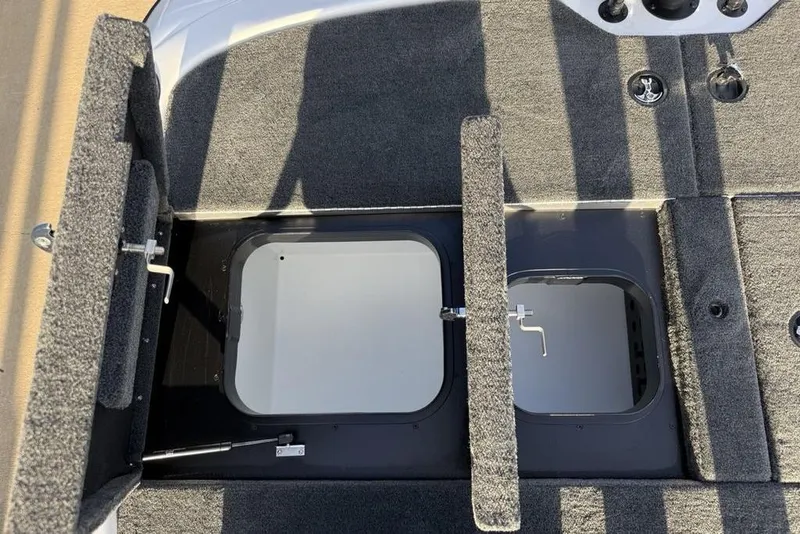 Slide: The Image of 2026 Skeeter ZXR19 SE boat storage compartments with open hatches and carpeted interior. - 24