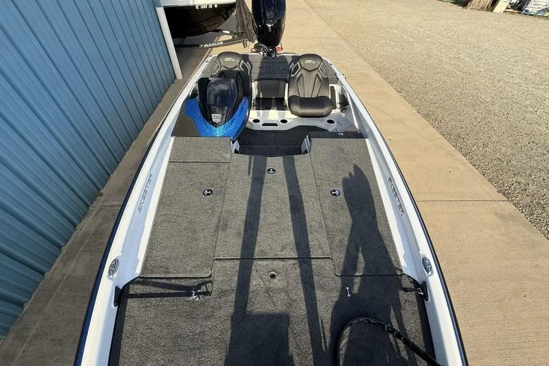 Slide: The Image of 2026 Skeeter ZXR19 SE boat with spacious deck and dual seats, parked near blue building. - 28