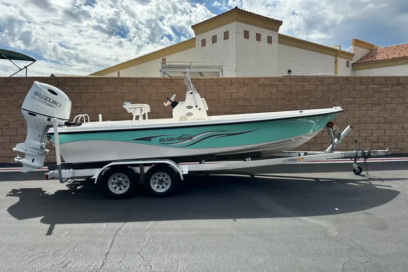 The Image of 2020 Blue Wave 2000 Classic boat on trailer, parked outdoors, featuring Suzuki engine. - 0
