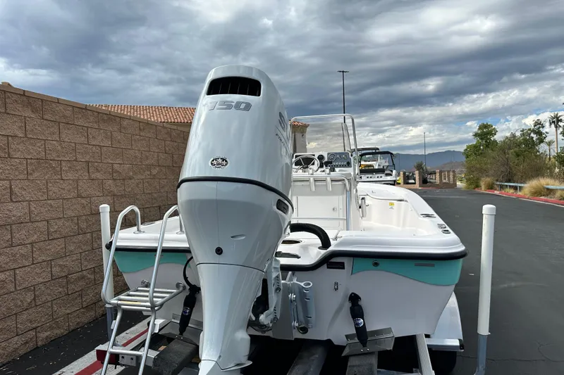 Slide: The Image of 2020 Blue Wave 2000 Classic boat with powerful outboard motor, parked under cloudy skies. - 3