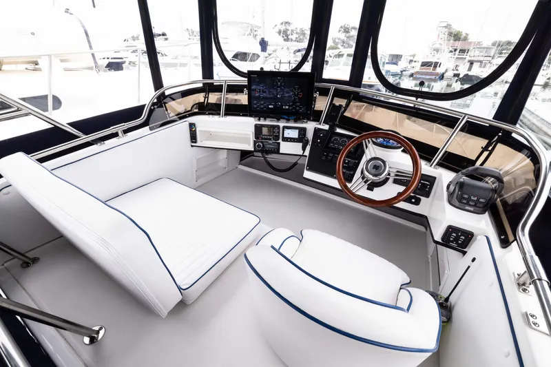 Slide: The Image of 2023 Skipjack 26 Flybridge helm with modern controls and white seating. - 17