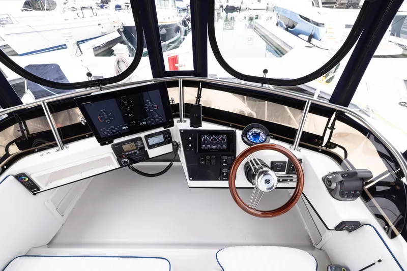 Slide: The Image of 2023 Skipjack 26 Flybridge helm with modern controls and navigation displays. - 19