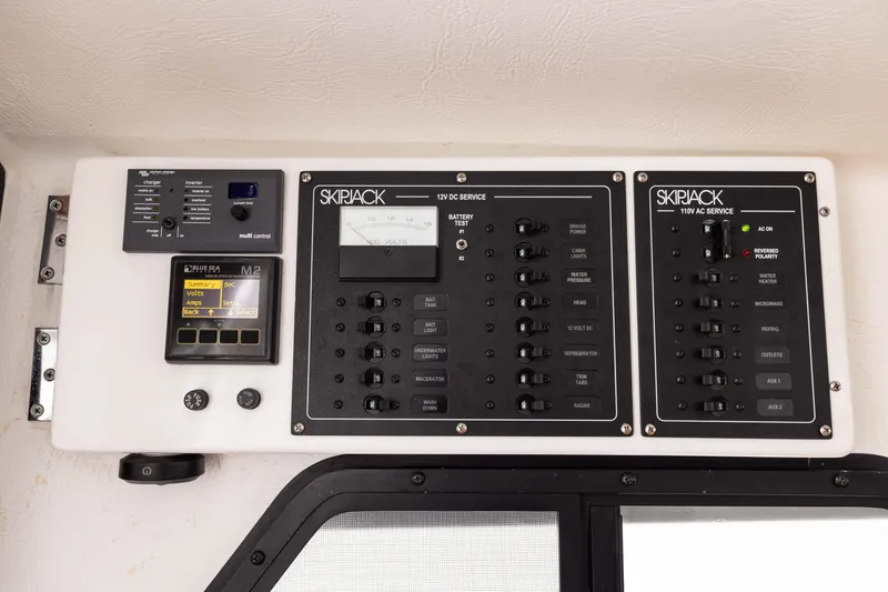 Slide: The Image of Control panel of 2023 Skipjack 26 Flybridge boat, featuring 12V and 110V service switches. - 22