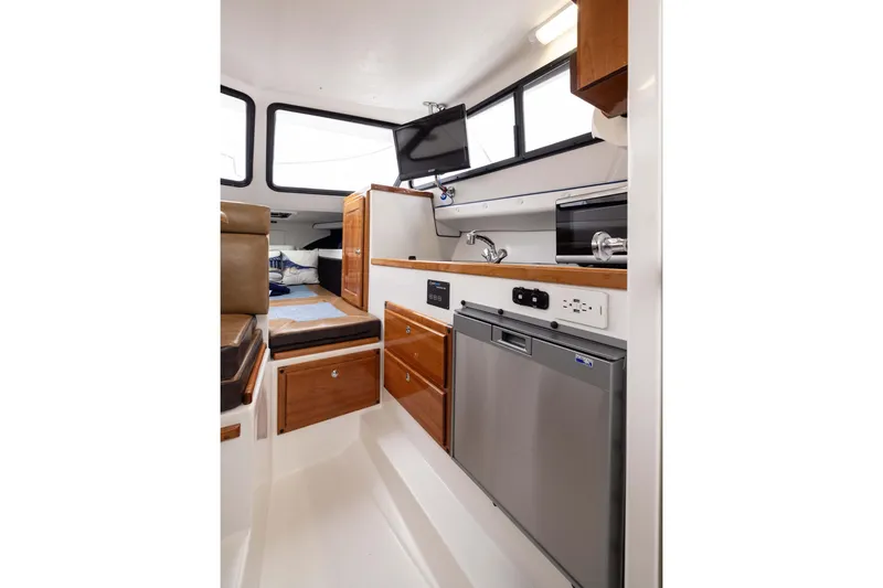 Slide: The Image of Interior of 2023 Skipjack 26 Flybridge with modern kitchen and seating area. - 24