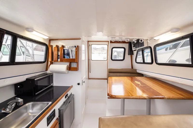 Slide: The Image of Interior of 2023 Skipjack 26 Flybridge boat with kitchenette and dining area. - 25