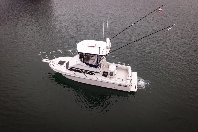 Slide: The Image of 2023 Skipjack 26 Flybridge boat cruising on calm water, aerial view. - 3
