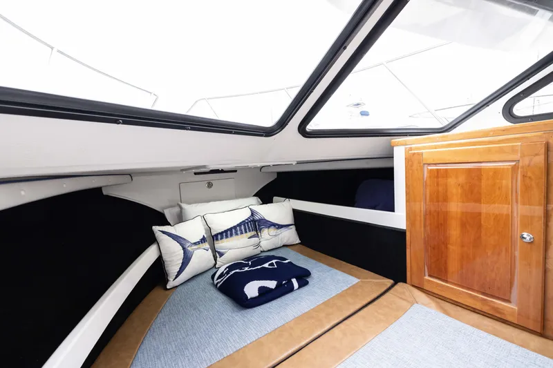 Slide: The Image of Interior of 2023 Skipjack 26 Flybridge boat with cozy cabin and nautical-themed pillows. - 35