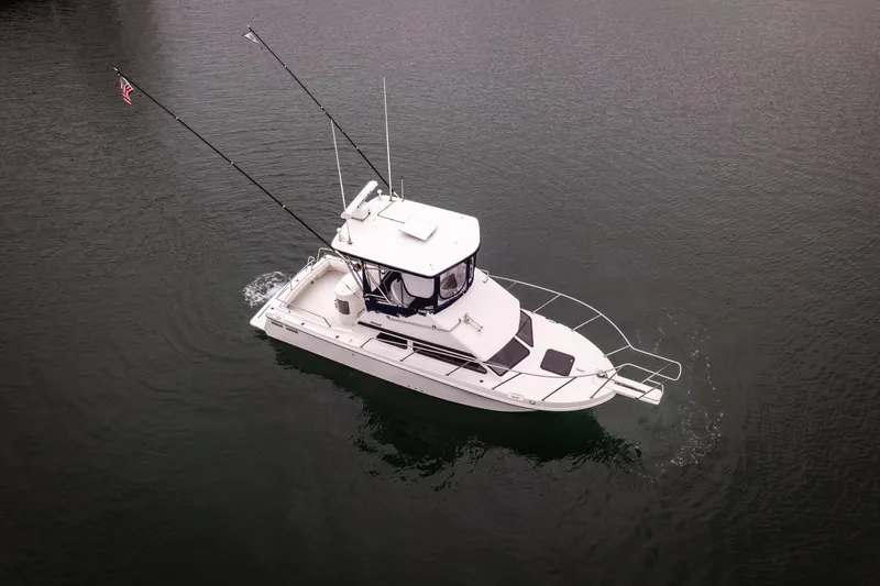 Slide: The Image of 2023 Skipjack 26 Flybridge boat cruising on calm water, aerial view. - 4