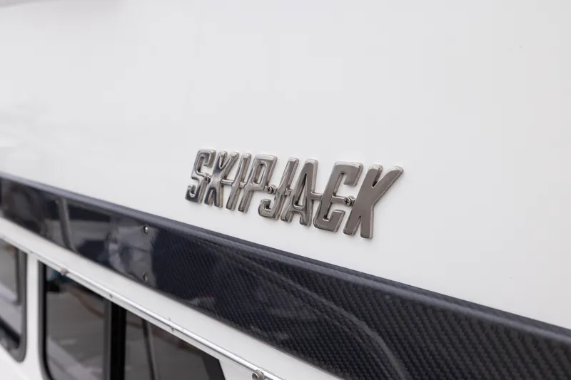 Slide: The Image of 2023 Skipjack 26 Flybridge boat logo on white exterior. - 9