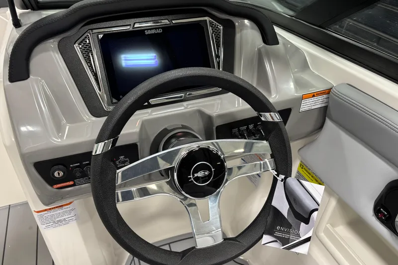 Slide: The Image of Steering wheel and dashboard of 2026 Chaparral 23 SSi boat, featuring Simrad display. - 13