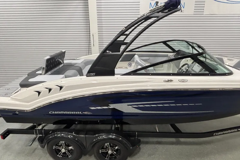 Slide: The Image of 2026 Chaparral 23 SSi boat with sleek design on a trailer in showroom. - 5
