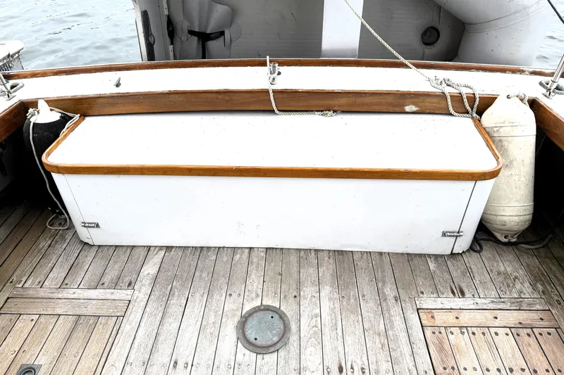 Slide: The Image of 1983 Wilbur 34 Fly Bridge Cruiser deck with wooden trim and storage compartment. - 11