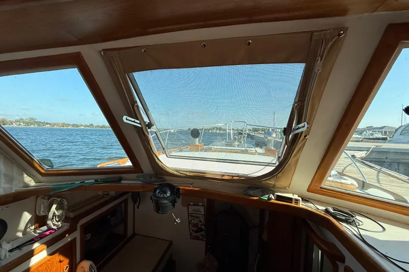 Slide: The Image of Interior view from 1983 Wilbur 34 Fly Bridge Cruiser, overlooking serene waters and marina. - 16