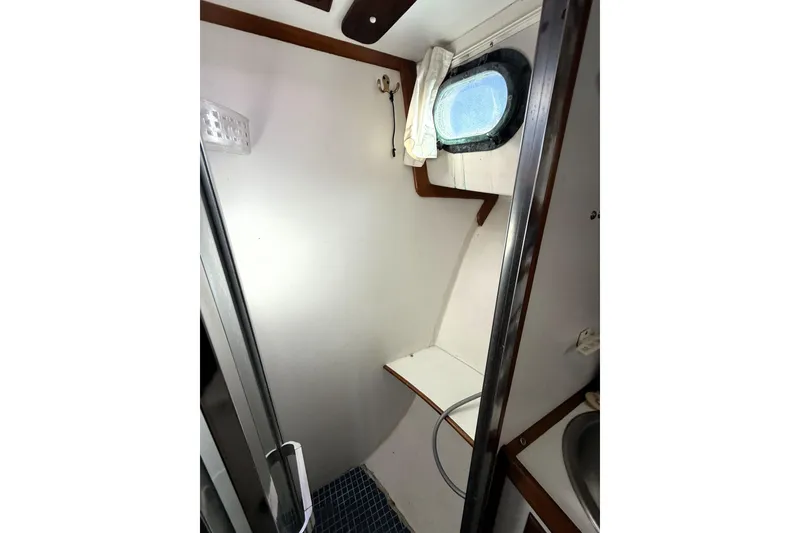 Slide: The Image of 1983 Wilbur 34 Fly Bridge Cruiser bathroom interior with porthole and shower. - 21