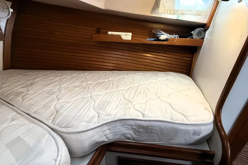 Slide: The Image of Interior cabin of 1983 Wilbur 34 Fly Bridge Cruiser with mattress and wooden accents. - 24