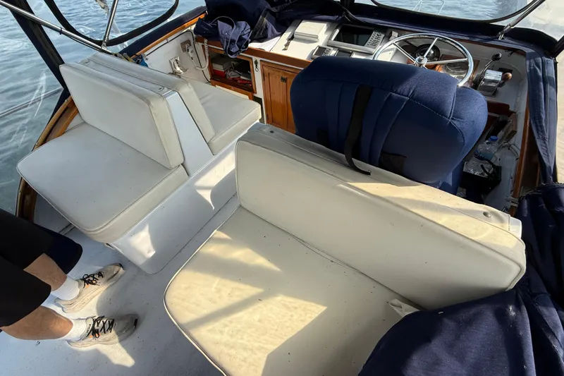 Slide: The Image of 1983 Wilbur 34 Fly Bridge Cruiser interior with white seating and steering wheel. - 26