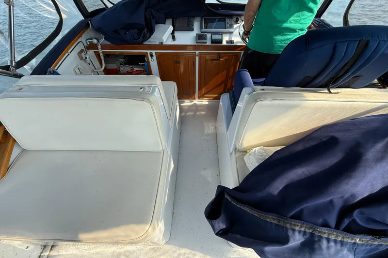 Slide: The Image of 1983 Wilbur 34 Fly Bridge Cruiser interior with seating and control panel. - 27