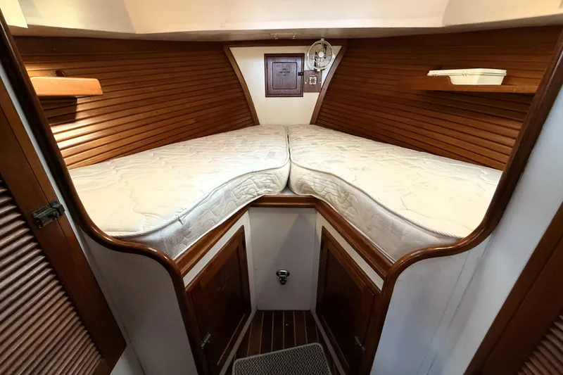Slide: The Image of Interior cabin of 1983 Wilbur 34 Fly Bridge Cruiser with wooden paneling and twin mattresses. - 3