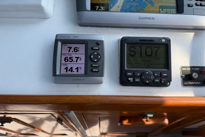 Slide: The Image of Control panel of 1983 Wilbur 34 Fly Bridge Cruiser with Garmin and Simrad displays. - 32