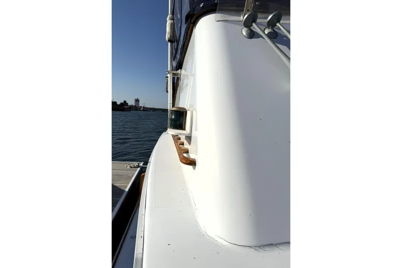 Slide: The Image of 1983 Wilbur 34 Fly Bridge Cruiser, side view, docked by the water. - 37