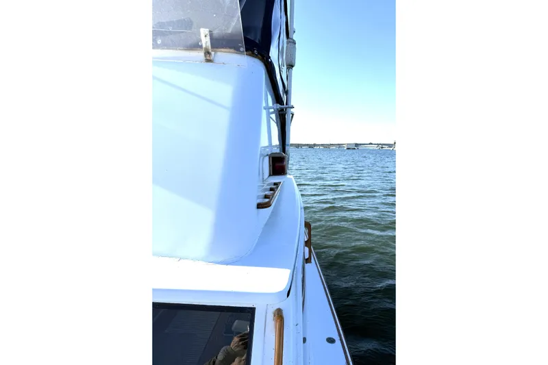Slide: The Image of 1983 Wilbur 34 Fly Bridge Cruiser on calm water, side view. - 38
