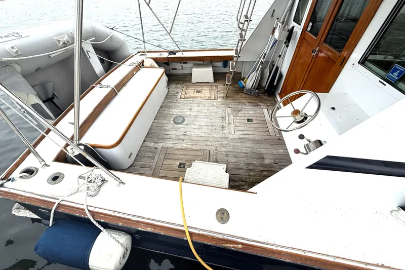 Slide: The Image of 1983 Wilbur 34 Fly Bridge Cruiser deck with wooden flooring and steering wheel. - 8