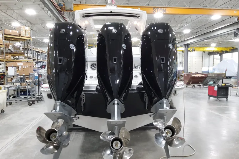 Slide: The Image of 2026 Formula 350 Crossover Bowrider OB with triple outboard engines in a workshop. - 14