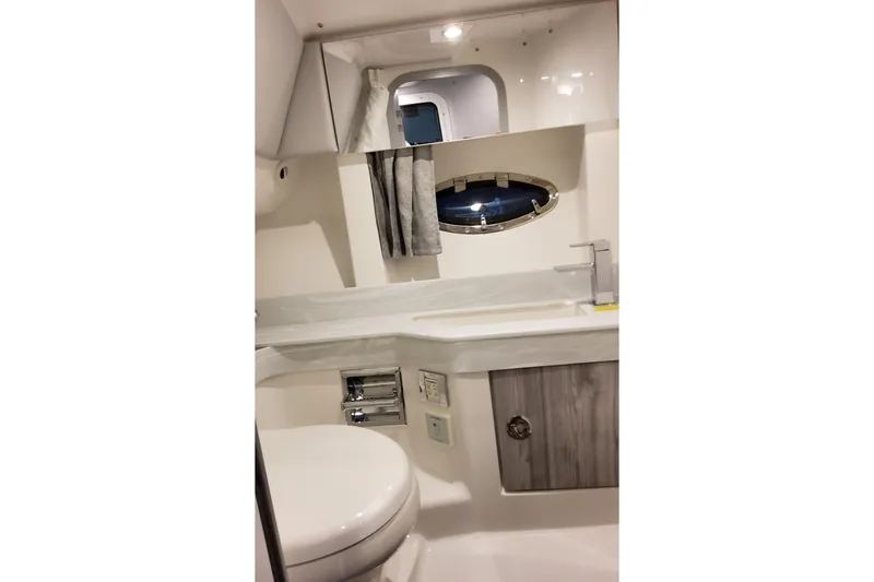 Slide: The Image of 2026 Formula 350 Crossover Bowrider OB bathroom with modern fixtures and porthole window. - 63