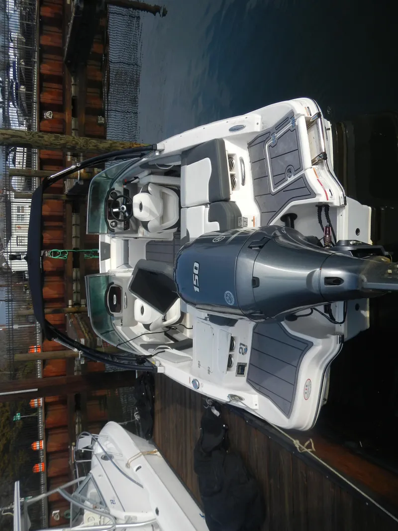 Slide: The Image of 2023 Chaparral 21 SSi OB boat docked, featuring a sleek design and powerful outboard motor. - 6