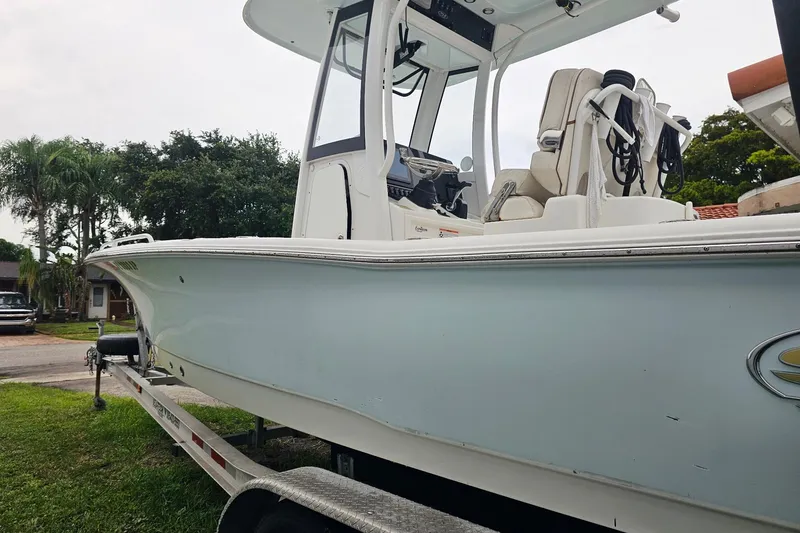 The Image of 2020 Sea Hunt BX 25 FS boat on trailer, parked on grass with trees in background. - 0