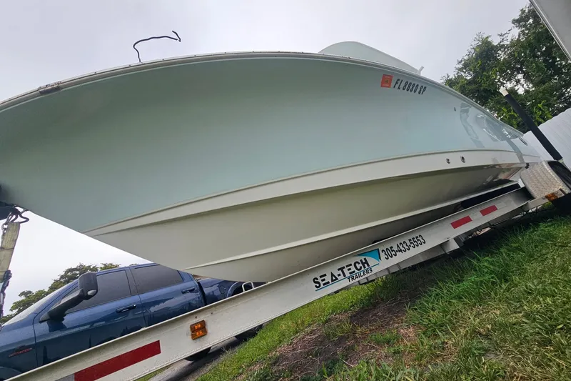 Slide: The Image of 2020 Sea Hunt BX 25 FS boat on trailer, side view, parked on grass. - 2
