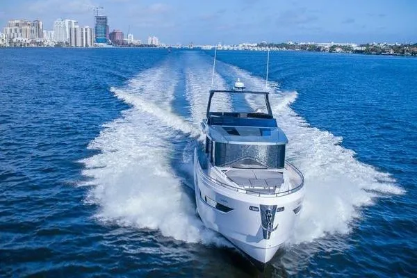 Slide: The Image of 2021 OKEAN FB Motor Yacht cruising on open water, city skyline in background. - 1