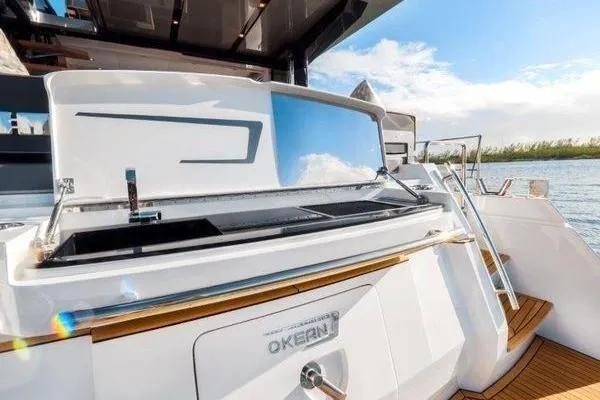 Slide: The Image of 2021 OKEAN FB Motor Yacht with sleek design, outdoor kitchen, and scenic water view. - 23