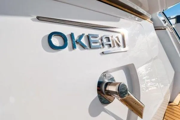 Slide: The Image of 2021 OKEAN FB Motor Yacht logo on sleek white exterior. - 24