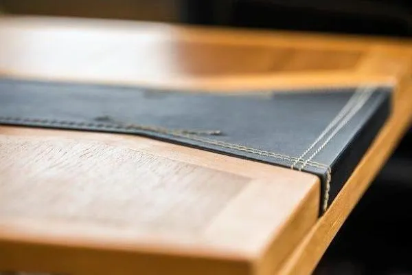 Slide: The Image of Close-up of a wooden table with a stitched leather cover on an OKEAN FB Motor Yacht, 2021. - 26