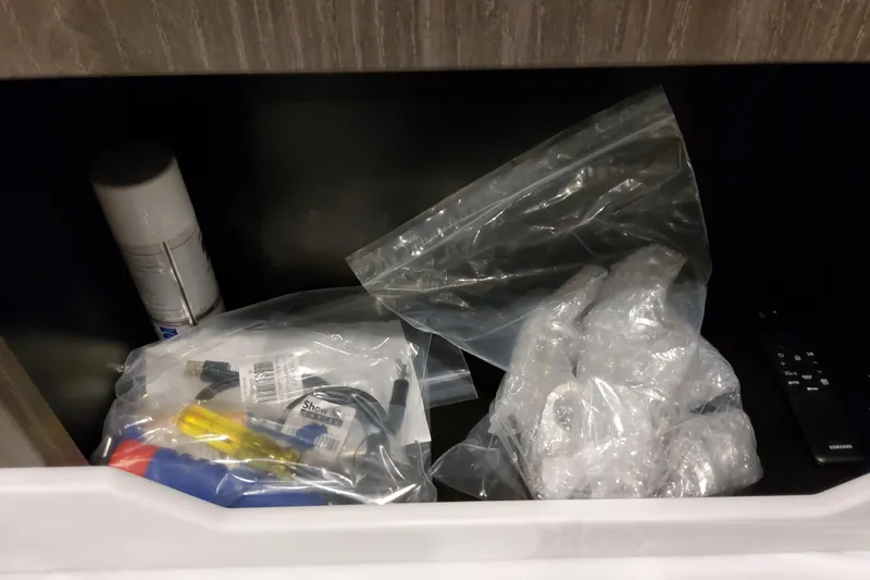 Slide: The Image of Storage compartment with cables, spray can, and bubble wrap in a Formula 380 Super Sport Crossover OB. - 110