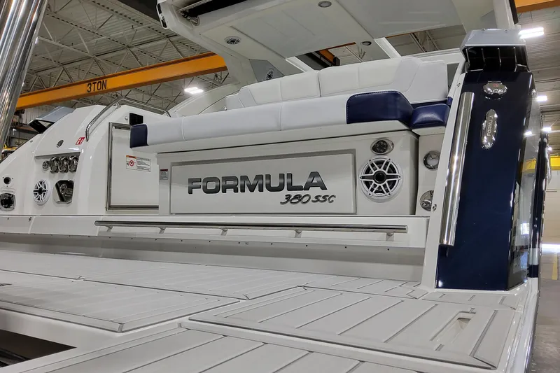 Slide: The Image of 2026 Formula 380 Super Sport Crossover OB boat, rear view in a warehouse setting. - 14