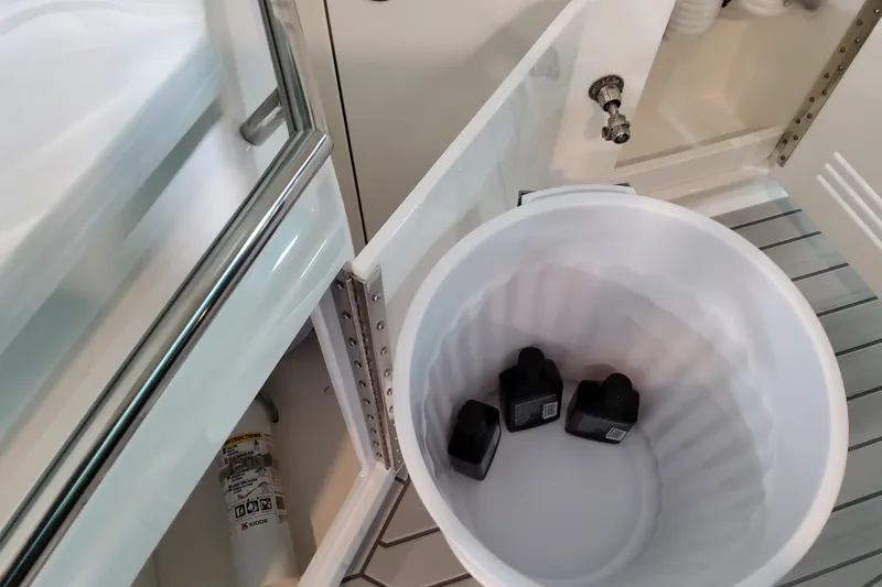 Slide: The Image of Open cabinet on Formula 380 Super Sport Crossover OB, showing a trash bin with bottles. - 48