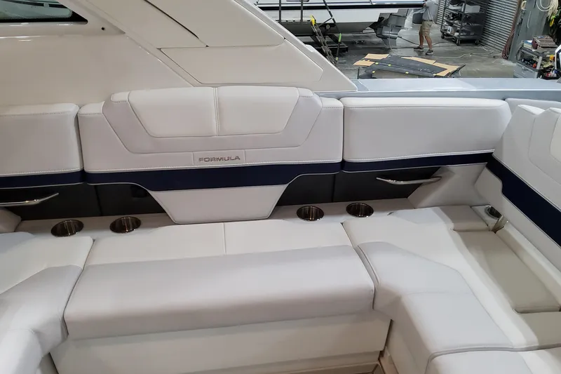 Slide: The Image of 2026 Formula 380 Super Sport Crossover OB boat interior with white seating and cup holders. - 58