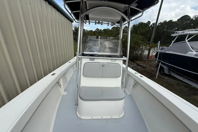 Slide: The Image of 2024 May-Craft 20 Cape Classic boat interior with seating and console, docked outdoors. - 10