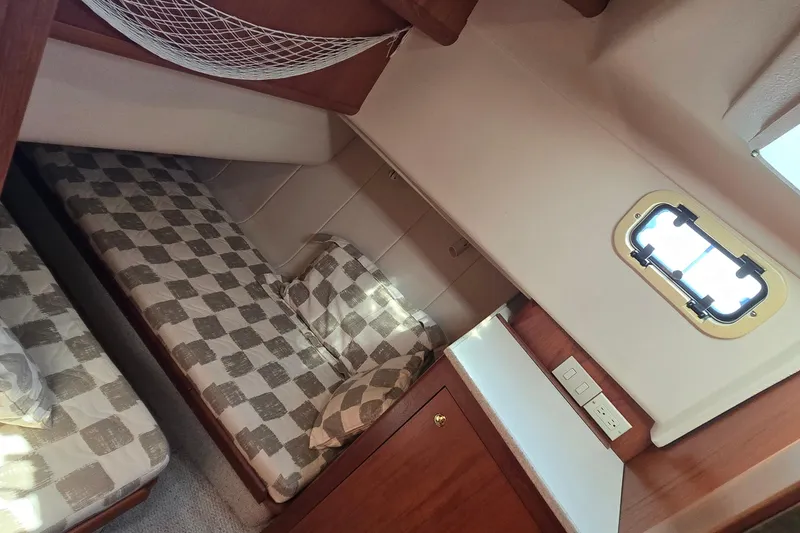 Slide: The Image of 2000 Mainship 390 Trawler cabin with twin beds and checkered bedding. - 10
