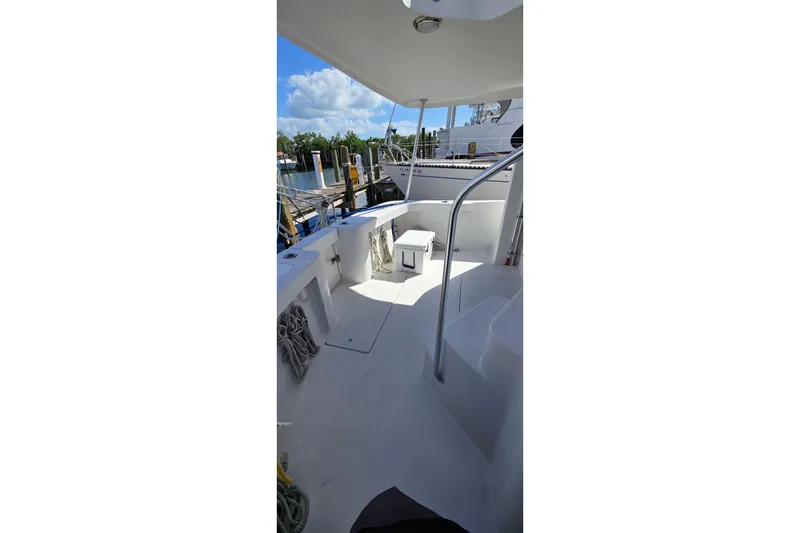 Slide: The Image of 2000 Mainship 390 Trawler deck view with seating and railing, docked at marina. - 17