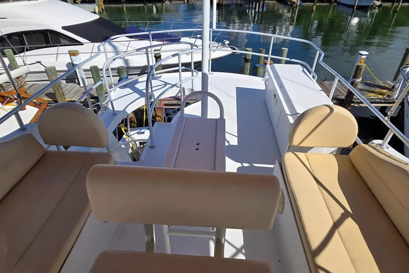 Slide: The Image of 2000 Mainship 390 Trawler deck with beige seating, docked at marina. - 21