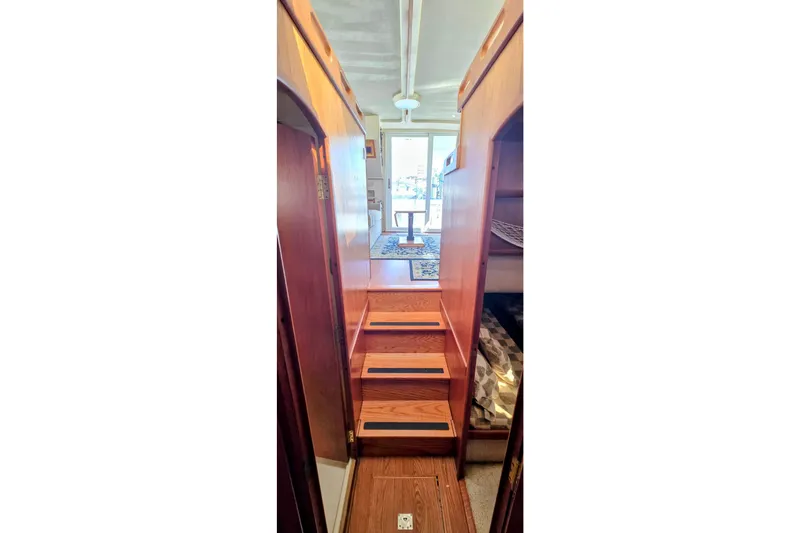 Slide: The Image of Interior view of 2000 Mainship 390 Trawler, featuring wooden stairs and cozy cabin space. - 6