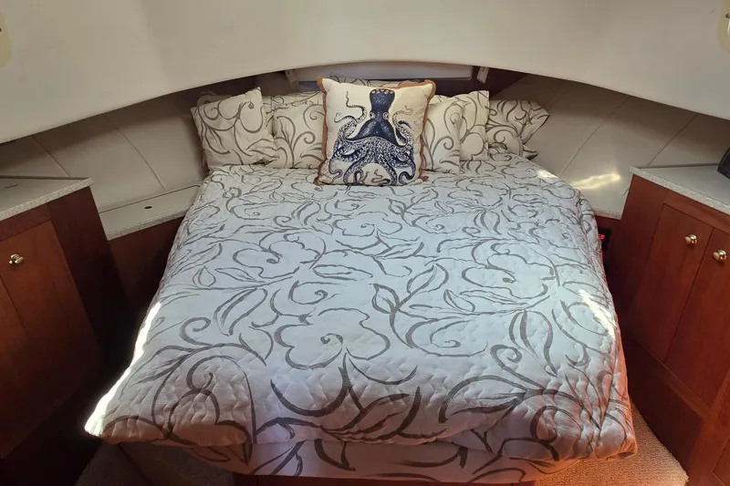 Slide: The Image of Cozy bedroom in 2000 Mainship 390 Trawler with nautical-themed decor and elegant bedding. - 7