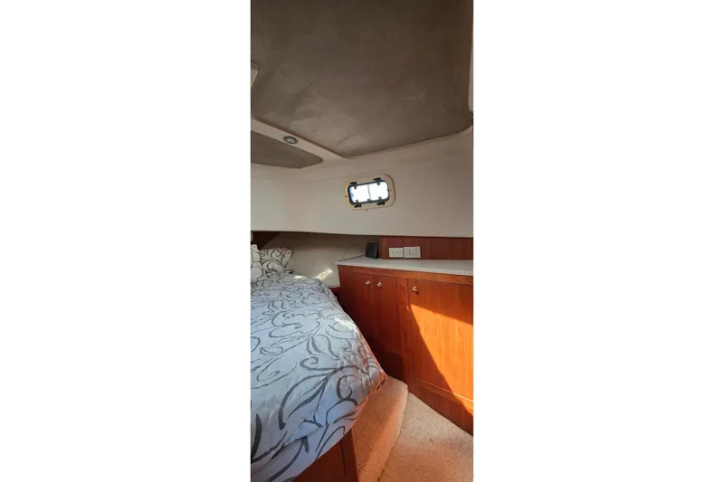 Slide: The Image of Cozy cabin interior of 2000 Mainship 390 Trawler with bed and wooden cabinetry. - 8