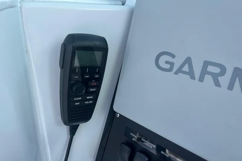 Slide: The Image of VHF radio and Garmin panel on 2025 Blackfin 252 CC boat dashboard. - 12