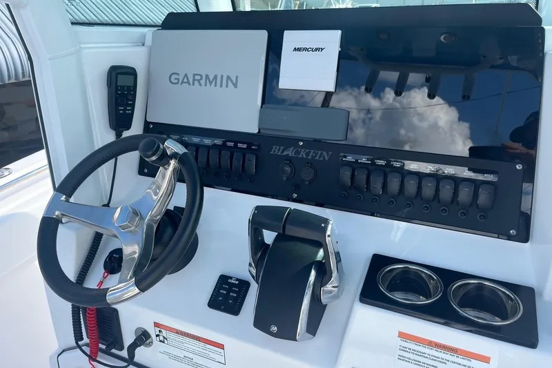 Slide: The Image of 2025 Blackfin 252 CC boat dashboard with Garmin and Mercury controls. - 17